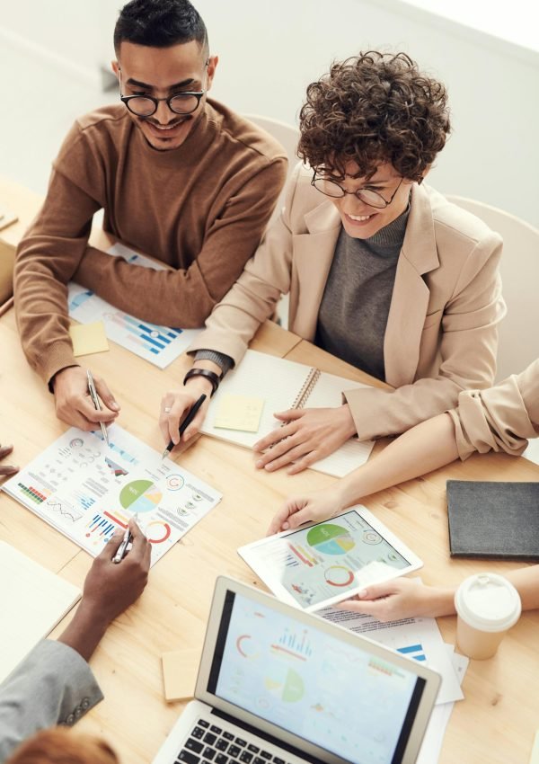 A diverse team of professionals collaborating over charts and graphs during a business meeting.